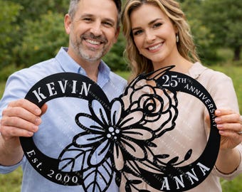 May include: Black metal anniversary sign with the names "Kevin" and "Anna" and the text "25th Anniversary" and "Est. 2000". The sign features a floral design and an infinity symbol shape.