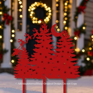 May include: Red metal Christmas yard art featuring silhouettes of pine trees, stars, a crescent moon, and Santa's sleigh with reindeer. The design is set against a snowy backdrop with Christmas lights.