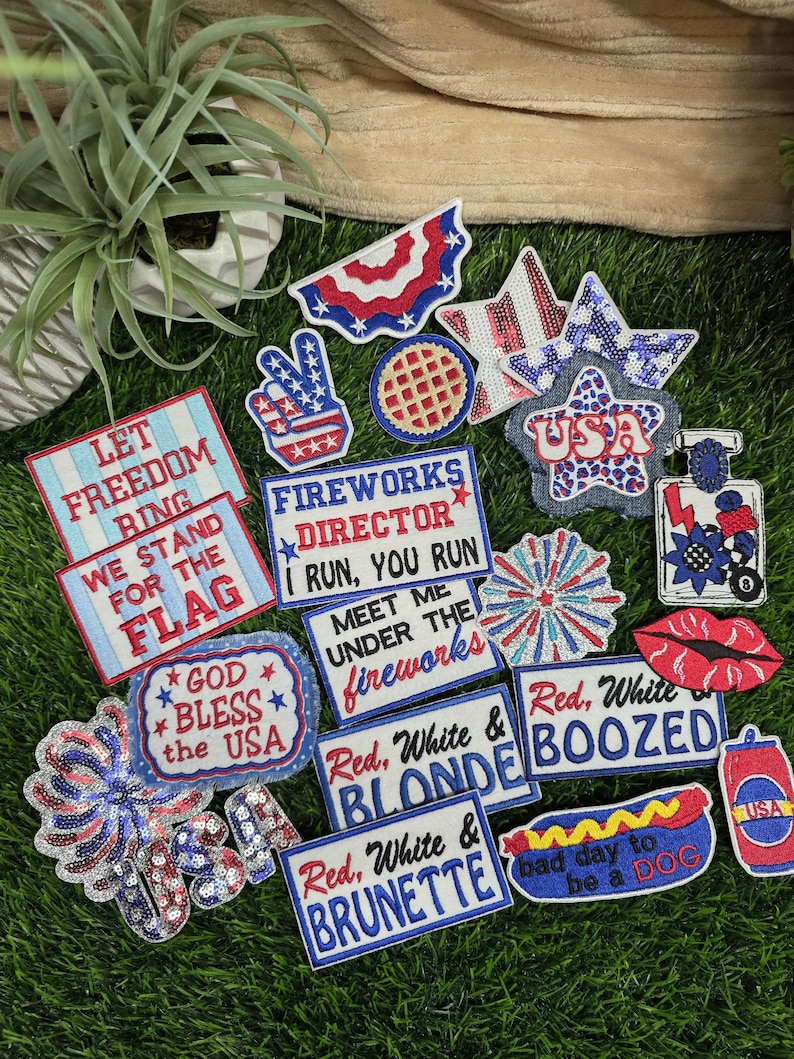 Pu&ograve; includere: Una collezione di toppe patriottiche rosse, bianche e blu. I disegni includono stelle, bandiere e testi come "Let Freedom Ring" e "God Bless the USA". Alcune toppe presentano paillettes.