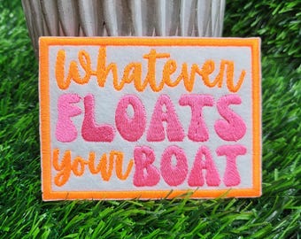 Embroidered iron-on patch with he saying Whatever Floats Your Boat in bright colors.