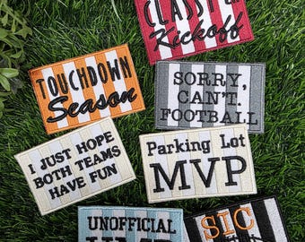Può includere: Una collezione di sette toppe rettangolari ricamate con sfondi a righe e testo nero o arancione. Le toppe presentano frasi tra cui CLASSY 'til Kickoff, TOUCHDOWN Season, SORRY, CAN'T. FOOTBALL, I JUST HOPE BOTH TEAMS HAVE FUN, Parking Lot MVP, UNOFFICIAL UMP e SIC 'EM.