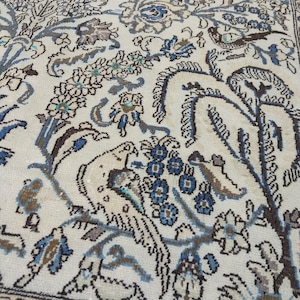 Alfombra persa cuadrada vintage de 5x7: Alfombra hecha a mano con estampado animal en tonos marrones y azules descoloridos.