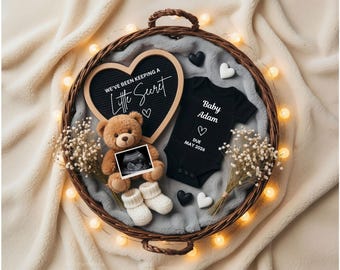 May include: A heartwarming pregnancy announcement. A woven basket holds a heart-shaped chalkboard with the text "We've been keeping a Little Secret", a teddy bear, baby ultrasound, and a black onesie that says "Baby Adam".