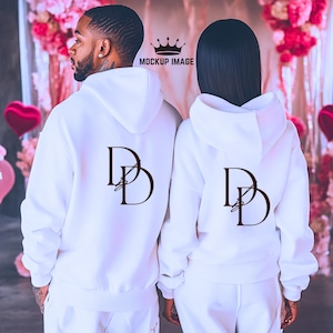 May include: Matching white hoodies with the letters "DD" in a dark brown script on the back. The hoodies have drawstrings and are part of a matching set. The image is a mockup.
