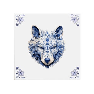 May include: A blue and white wolf head with intricate floral patterns, against a white background. The wolf's eyes are open and the mouth is closed. The image is surrounded by four small blue flowers.