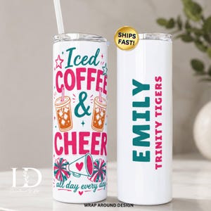 May include: Two white cylindrical tumblers with lids and straws. One features the text Iced Coffee & Cheer with illustrations of two iced coffee cups, a megaphone, and pom-poms in pink and teal. The other displays the name Emily and Trinity Tigers.