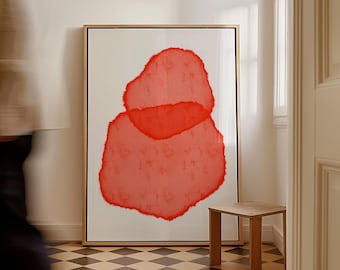 May include: Large framed abstract art print featuring two overlapping red organic shapes on a white background. The artwork is displayed in a room with a small wooden stool and a checkered floor.