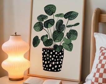 May include: A framed botanical print featuring a potted plant with large, dark green leaves speckled with white dots. The pot is black with white polka dots. A glowing, ribbed, peach-colored lamp and an open book sit on a nightstand.