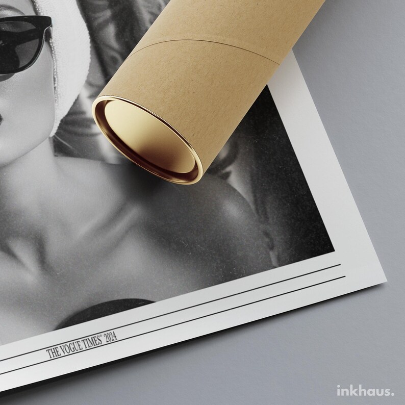 May include: A black and white photographic print featuring a person wearing sunglasses and a head wrap, partially covered by a cylindrical cardboard shipping tube. The print includes the text THE VOGUE TIMES 2024 and the brand name inkhaus.