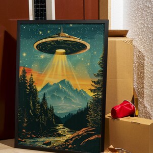Vintage UFO Wall Art featuring a retro flying saucer illustration with vibrant blue tones, set against a psychedelic alien mountain landscape. This unique and surreal poster brings a cosmic, otherworldly atmosphere to any room, making it the perfect decor piece for sci-fi enthusiasts or those looking for bold, eclectic design. Whether displayed in a living room, bedroom, or office, this striking print adds personality and a conversation-starting element to your home decor.