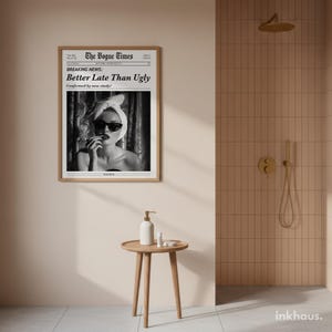 May include: A framed wall art print titled The Vogue Times featuring a black and white photograph of a person wearing a towel on their head and sunglasses, with the text Breaking News: Better Late Than Ugly, Confirmed by new study!