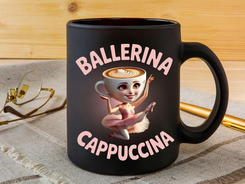 Może przedstawiać: Czarny ceramiczny kubek z r&oacute;żowymi napisami "Ballerina Cappuccina". Kubek przedstawia kresk&oacute;wkową baletnicę z filiżanką kawy zamiast głowy. Baletnica ma na sobie r&oacute;żowe tutu i jest w pozie baletowej.