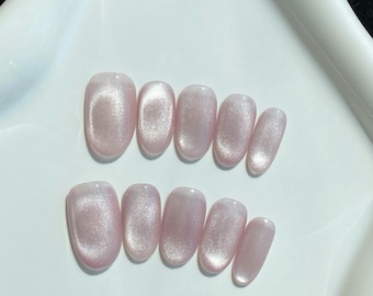Uñas postizas con purpurina y efecto ojo de gato rosa: estilo minimalista