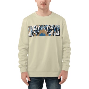 Op de afbeelding: Een lichtbeige sweatshirt met een kleurrijke tijgergezichtsprint op de voorkant. De ogen van de tijger zijn blauw.