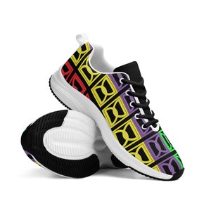 Op de afbeelding: Witte sneakers met een zwarte achtergrond en een kleurrijk geometrisch patroon in rood, geel, groen en paars.