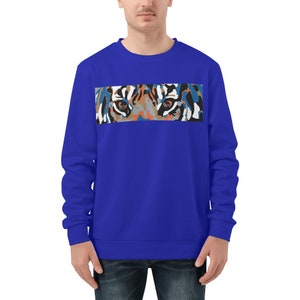 Op de afbeelding: Een koninklijk blauw sweatshirt met een kleurrijke tijgergezichtsprint over de borst. De ogen van de tijger zijn het meest opvallende kenmerk van het ontwerp.