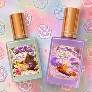May include: Two rectangular glass perfume bottles with metallic gold caps. The left bottle is light green with a label featuring a brown kitten and the text Velour Kittens Tropical Banana Whip. The right bottle is purple with a label featuring a white kitten and the text Velour Kittens Original.