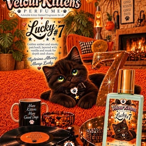 May include: A rectangular light blue perfume bottle labeled Velour Kittens Lucky #7 with a gold cap, featuring a black kitten illustration. The bottle sits near a black mug with text, a vinyl record, and a large gold number seven on a shag rug.