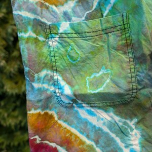 Peut inclure: Un tissu tie-dye avec une grande poche. Le tissu est un m&eacute;lange de couleurs bleues, vertes, jaunes et rouges.