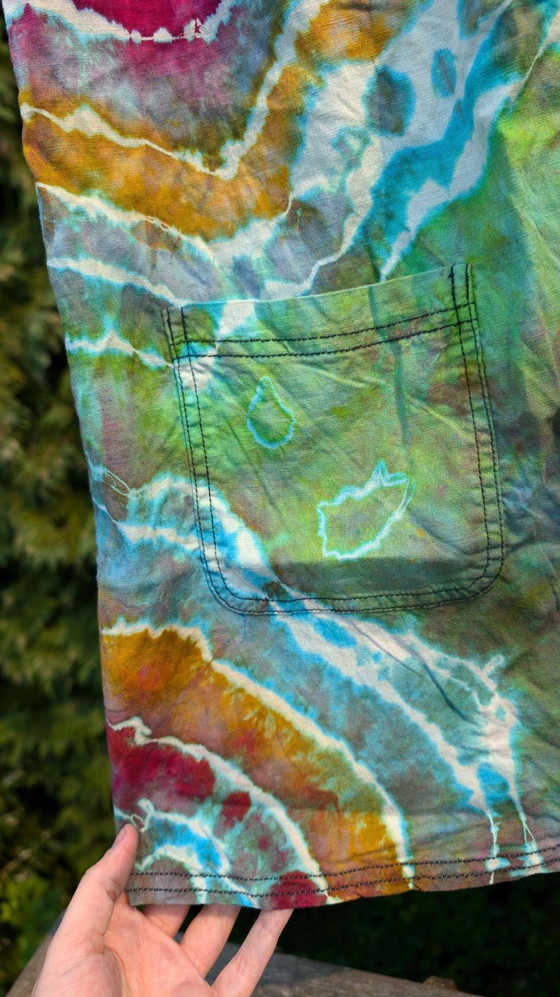 Peut inclure: Un tissu tie-dye avec une grande poche. Le tissu est un m&eacute;lange de couleurs bleues, vertes, jaunes et rouges.