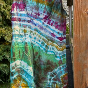 Peut inclure: Un d&eacute;bardeur tie-dye avec un motif en spirale color&eacute; dans des tons de rose, bleu, vert et jaune. Le d&eacute;bardeur est suspendu &agrave; une corde &agrave; linge.