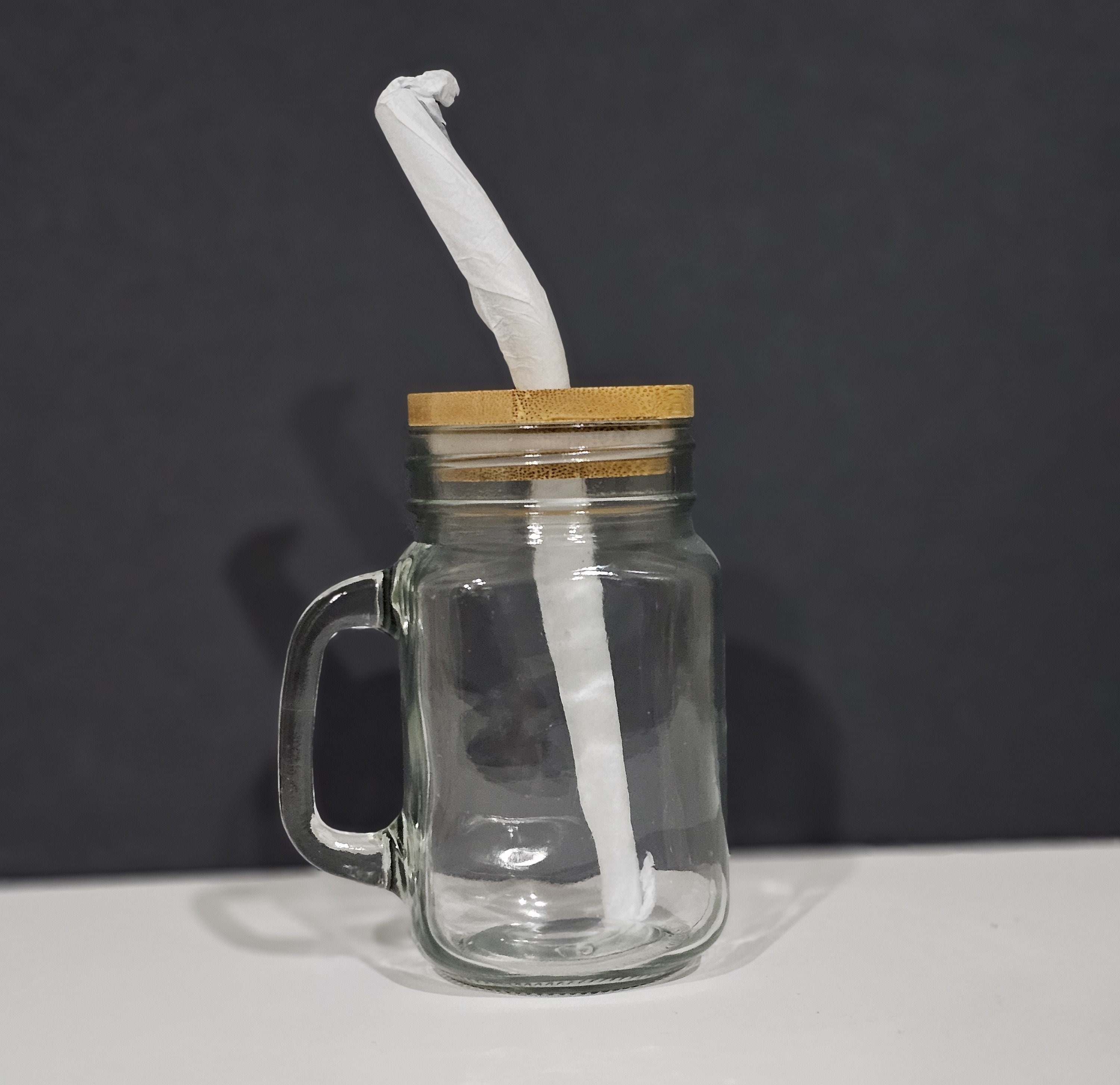 Violet glass cup with lid and straw on a white background isolated. Mason  jar with handle and screwed down cap. Empty mug no spill. Stock Photo