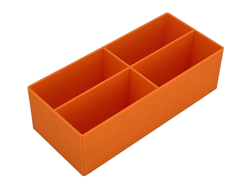 May include: Orange rectangular organiser with four compartments. This storage container is made of a solid, opaque material and is designed to hold and separate various items. The compartments are evenly sized.