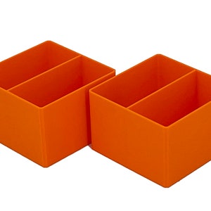 May include: Two orange plastic desk organizers with two compartments each.