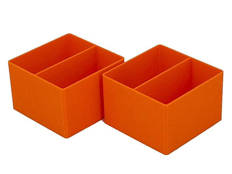 May include: Two orange plastic desk organizers with two compartments each.