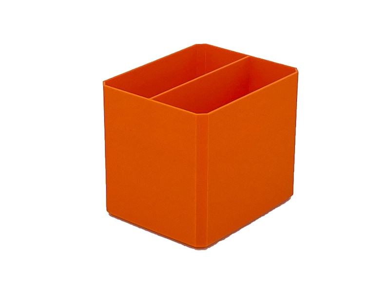 Pode incluir: Um organizador de secret&aacute;ria laranja com dois compartimentos. O organizador retangular &eacute; feito de um material s&oacute;lido e foi concebido para guardar material de escrit&oacute;rio. A cor &eacute; um laranja brilhante e s&oacute;lido.