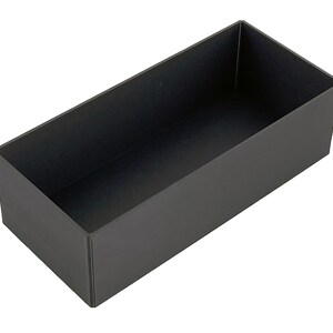 May include: A black rectangular storage box with a smooth surface.