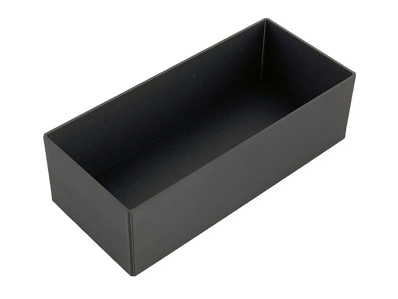 May include: A black rectangular storage box with a smooth surface.