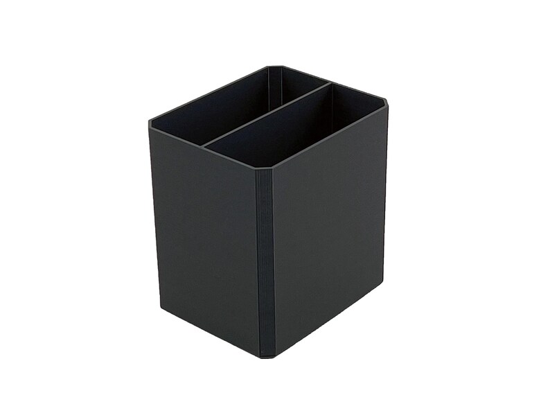 May include: A black desk organizer with two compartments. The organizer is rectangular with a vertical divider and is made of a matte material. The design is simple and modern, suitable for office or home use.