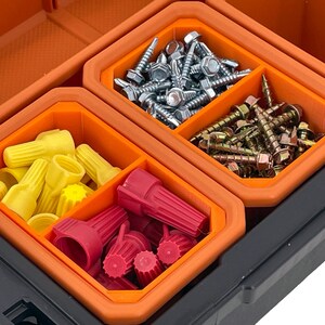 Puede incluir: Una caja de herramientas de pl&aacute;stico naranja y negro con cuatro compartimentos. Los compartimentos est&aacute;n llenos de varios art&iacute;culos de ferreter&iacute;a, incluidos conectores de cables, tornillos y clavos.