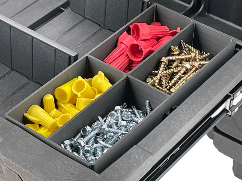 May include: A black plastic storage box with four compartments. The compartments are filled with various hardware items, including red and yellow wire connectors, silver screws, and gold screws.