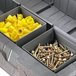 May include: A gray plastic storage box with two compartments. The top compartment is filled with yellow wire connectors. The bottom compartment is filled with gold screws.