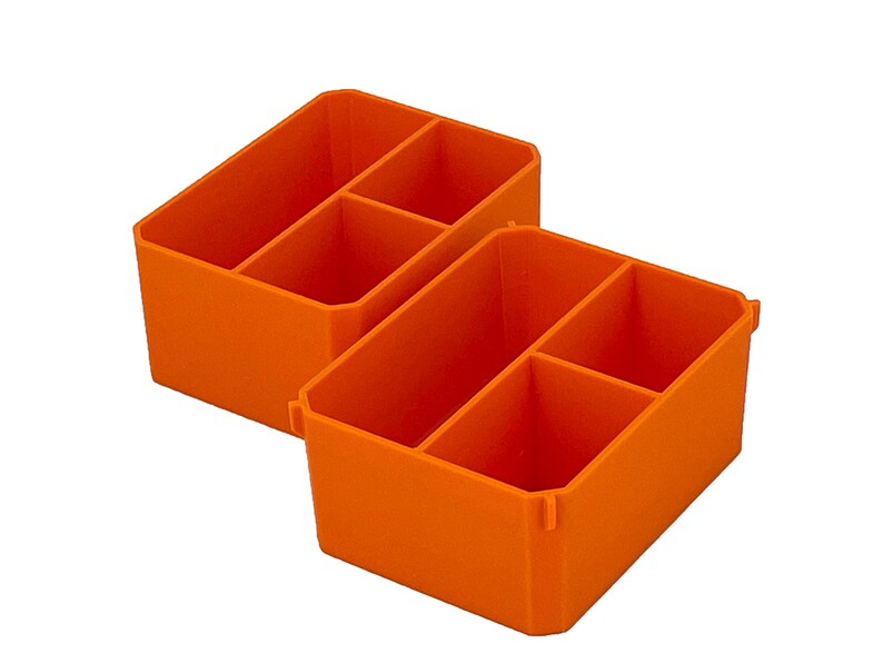 May include: Two bright orange plastic organiser bins. Each bin is divided into three compartments. The bins are designed to hold small items and keep them organised. The bins are made of a durable plastic material.