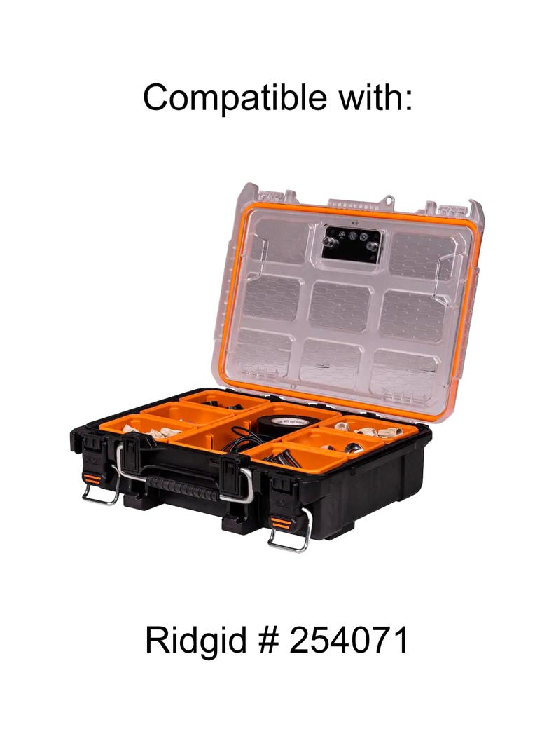Puede incluir: Una caja de herramientas negra y naranja abierta con una tapa transparente. La caja de herramientas est&aacute; llena de varias herramientas y accesorios. El texto "Ridgid # 254071" est&aacute; impreso en la parte inferior de la imagen.