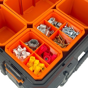 Puede incluir: Una caja de herramientas negra y naranja con m&uacute;ltiples compartimentos llenos de diversos art&iacute;culos de ferreter&iacute;a, incluidos tornillos, tuercas, conectores de cables y otras piezas peque&ntilde;as.