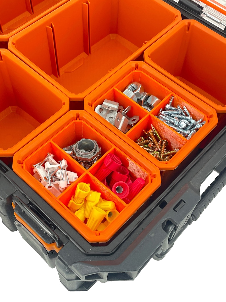 Puede incluir: Una caja de herramientas negra y naranja con m&uacute;ltiples compartimentos llenos de diversos art&iacute;culos de ferreter&iacute;a, incluidos tornillos, tuercas, conectores de cables y otras piezas peque&ntilde;as.