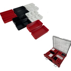 May include: A set of red, black and white plastic storage containers with multiple compartments. The containers are stacked on top of each other. There is also a larger red storage container with multiple compartments that is open.