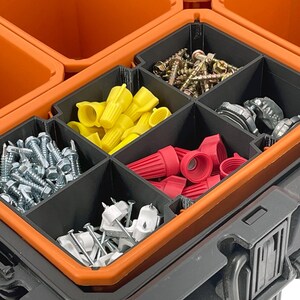 May include: A black and orange toolbox with multiple compartments filled with various hardware items. The compartments contain screws, wire connectors, and other small parts, ideal for organizing tools and supplies.