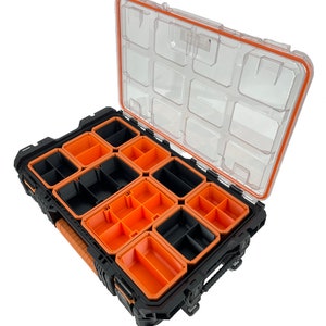 Peut inclure: Une bo&icirc;te &agrave; outils noire et orange ouverte avec un couvercle transparent. La bo&icirc;te &agrave; outils comporte plusieurs compartiments et est compatible avec Ridgid #238093.