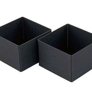 May include: Two black square-shaped storage boxes made of plastic. The boxes are empty and are sitting next to each other on a white background.
