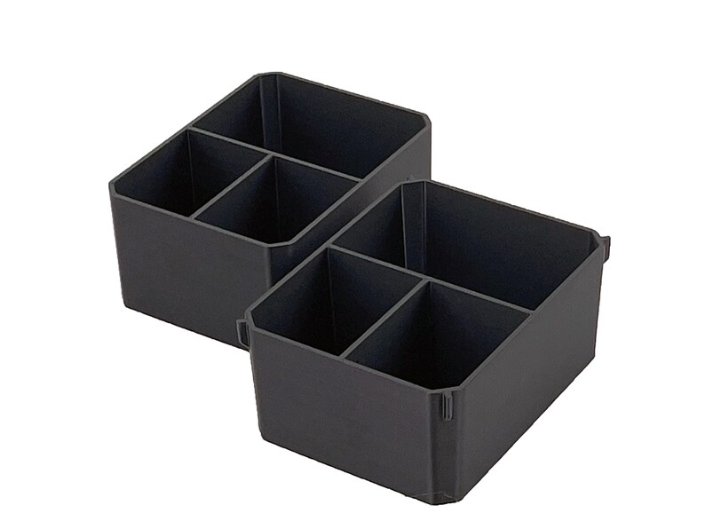 Op de afbeelding: Twee zwarte plastic opbergorganizers met meerdere compartimenten. Elke organizer heeft een rechthoekige vorm met interne verdelers, waardoor aparte secties ontstaan voor het opbergen van items. De organizers zijn ontworpen om items georganiseerd te houden.