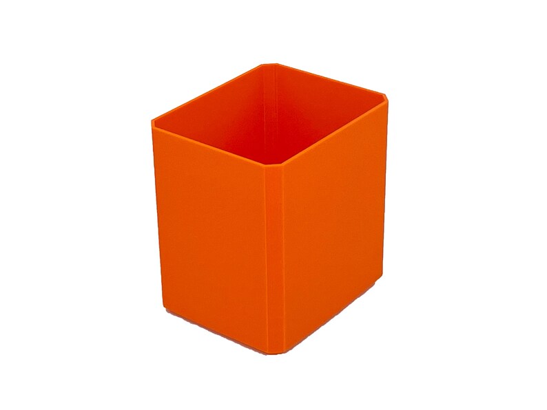 May include: An orange rectangular container with a square opening. The container is made of a solid, opaque material and has a smooth surface. The container is empty and sits on a white background. The container is a vibrant shade of orange.