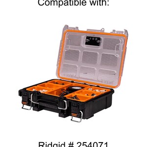 Op de afbeelding: Een open zwarte en oranje gereedschapskist met een doorzichtig deksel. De gereedschapskist is gevuld met verschillende gereedschappen en accessoires. De tekst "Ridgid # 254071" staat onderaan de afbeelding.