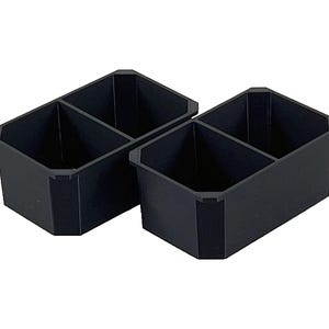 Op de afbeelding: Twee zwarte plastic opbergbakken met verdelers. Elke bak heeft twee compartimenten.