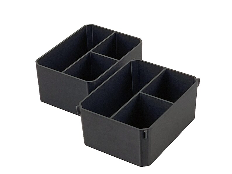 Op de afbeelding: Twee donkergrijze plastic organizers met meerdere compartimenten. Elke organizer heeft een schuin ontwerp en is verdeeld in vier secties, ideaal voor bureau- of lade-organisatie. De organizers worden tegen een witte achtergrond getoond.