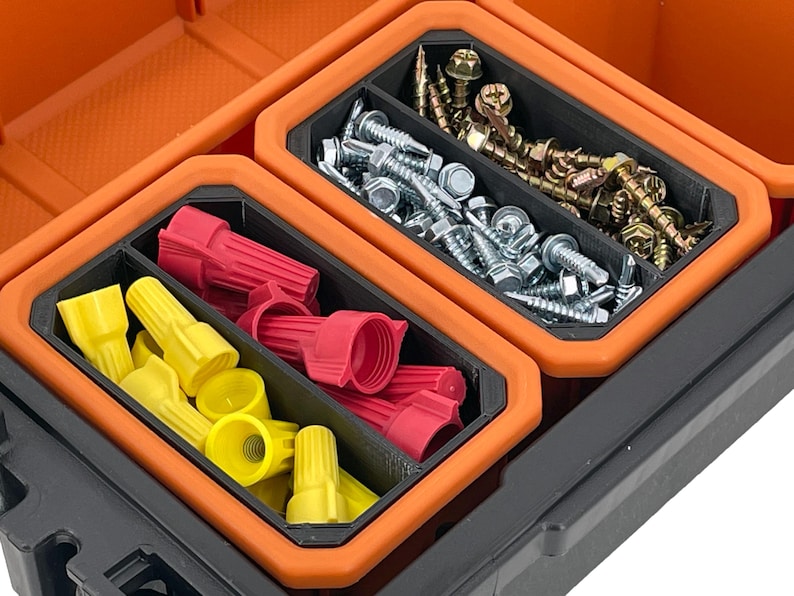 Op de afbeelding: Een oranje en zwarte plastic opbergdoos met drie compartimenten. De compartimenten bevatten verschillende hardware-items, waaronder schroeven, draadconnectoren en moeren.
